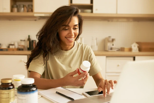 Imagen ilustrativa de una mujer buscando información sobre su envase de vitaminas.